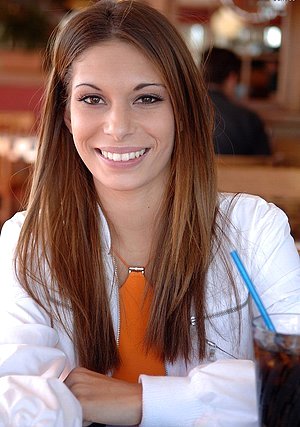 Cheery girl from the garage shows her boobs next to a sports car
