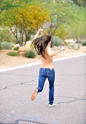 Topless babe proudly showcasing her breasts while running on the road